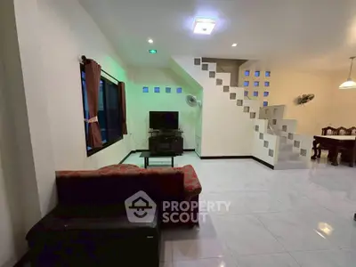 Spacious living room with modern staircase and dining area, perfect for family gatherings.