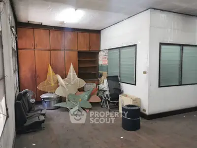 Spacious storage room with wooden cabinets and ample natural light, ideal for organization and utility.