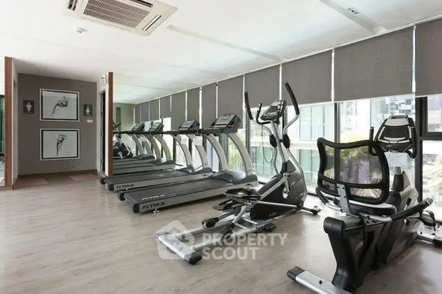 Modern gym with treadmills and exercise equipment in a bright, spacious room.