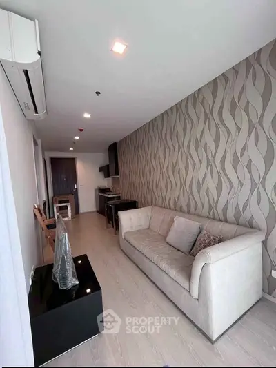 Modern living room with stylish wallpaper and cozy sofa in a sleek apartment.