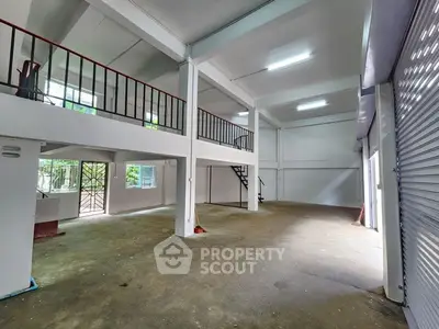 Spacious industrial-style warehouse with mezzanine and ample natural light.