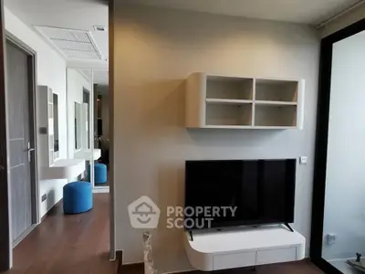 Modern living room with sleek TV setup and stylish shelving in a contemporary apartment.