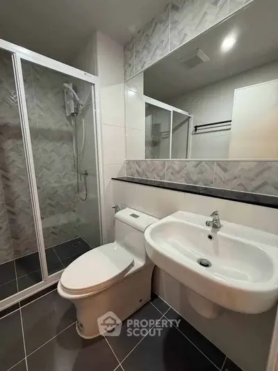 Modern bathroom with sleek shower and stylish tiles in contemporary apartment.