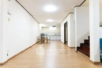 Spacious open-plan living area with wooden flooring and modern kitchen.