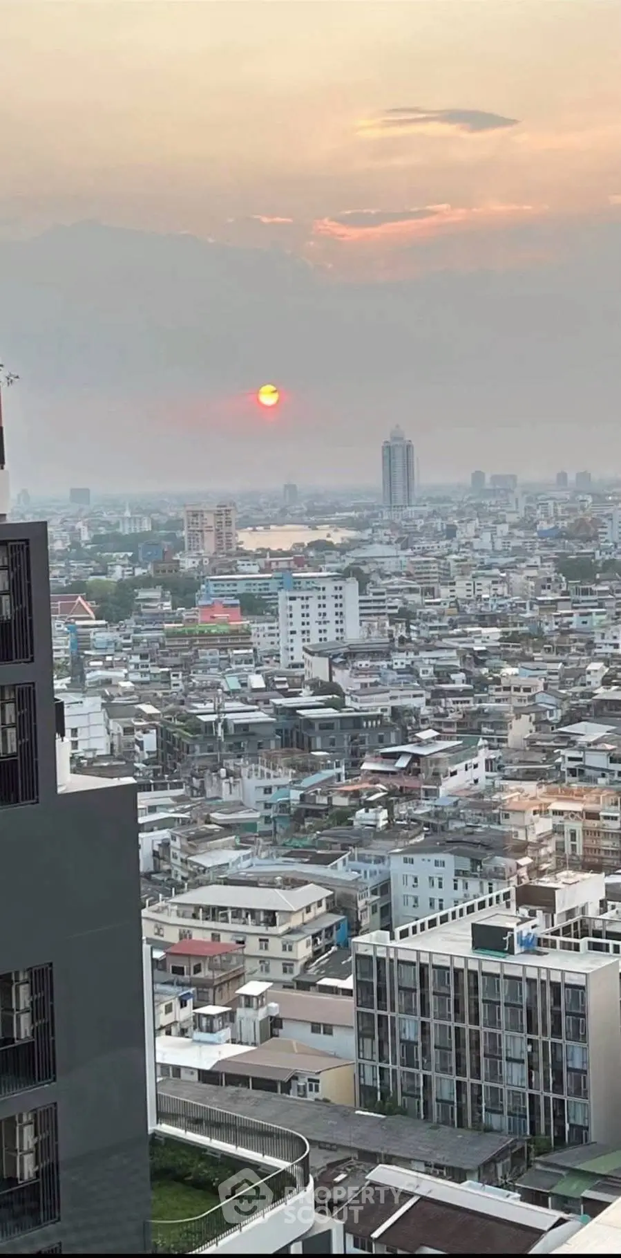Stunning cityscape view from high-rise building at sunset, showcasing urban skyline and vibrant horizon.