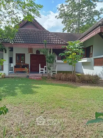 Charming traditional house with lush garden and inviting porch, perfect for serene living.