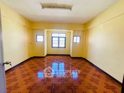 Spacious room with unique patterned floor tiles and ample natural light.