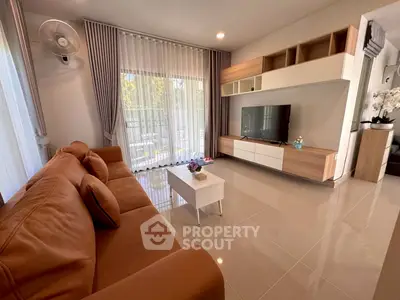Modern living room with large sofa, sleek TV unit, and floor-to-ceiling windows for natural light.