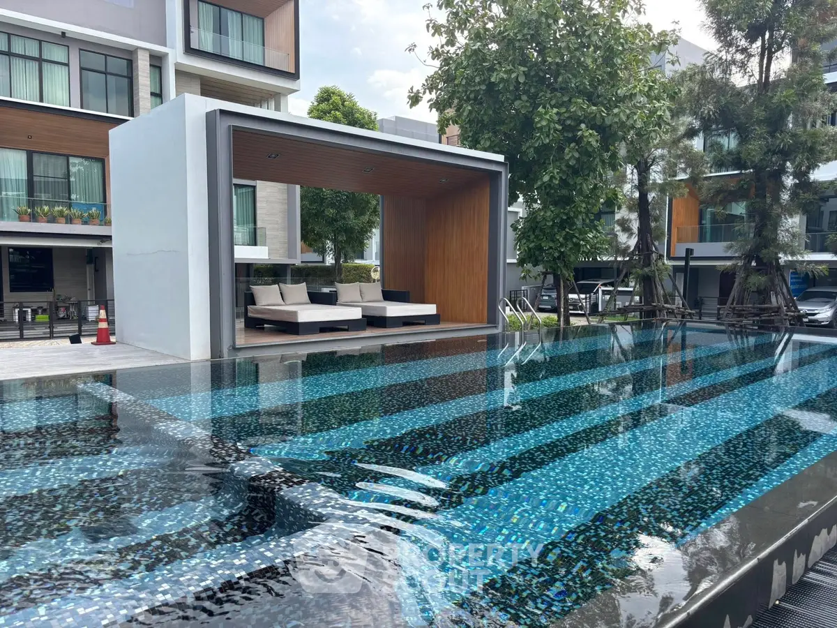 Luxurious modern apartment complex with stunning outdoor pool and stylish cabana area.
