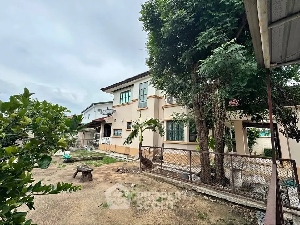 Charming two-story house with spacious yard and lush greenery, perfect for family living.