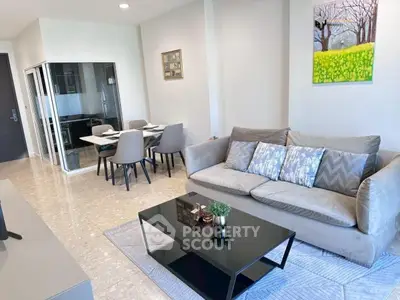 Modern living room with elegant decor and dining area, featuring a cozy sofa and stylish table.