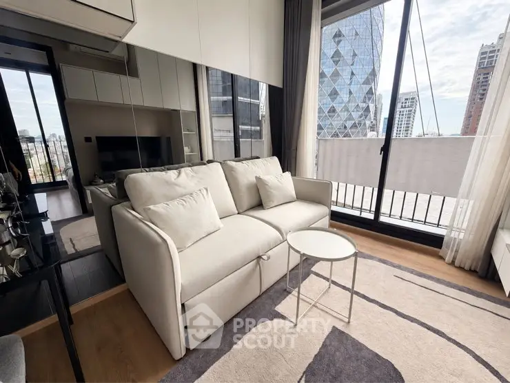 Modern living room with large windows and city view, featuring a cozy sofa and stylish decor.