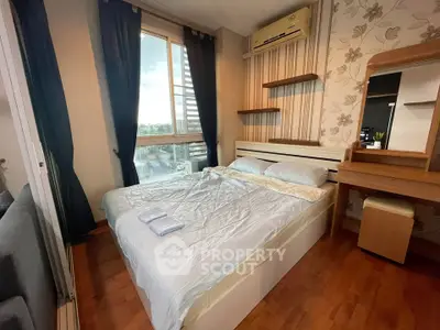 Cozy bedroom with wooden flooring, large window, and stylish decor in modern apartment.