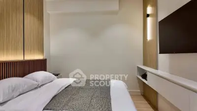 Modern bedroom with sleek design, featuring a wall-mounted TV and elegant lighting.