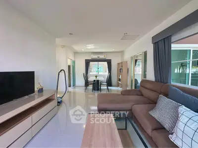 Spacious modern living room with sleek furniture and large windows offering natural light.
