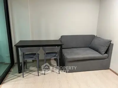 Cozy living room with modern gray sofa and sleek dining table, perfect for compact urban living.