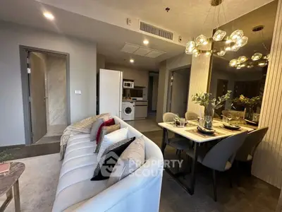 Modern open-plan living and dining area with stylish decor and contemporary lighting.