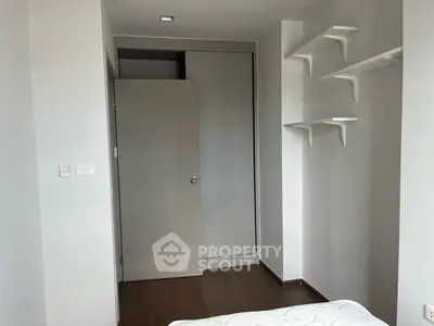 Minimalist bedroom with built-in closet and wall shelves