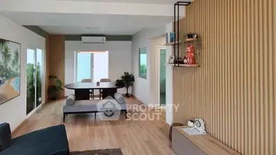Modern living room with stylish decor and wooden flooring, featuring a spacious layout and elegant furniture.