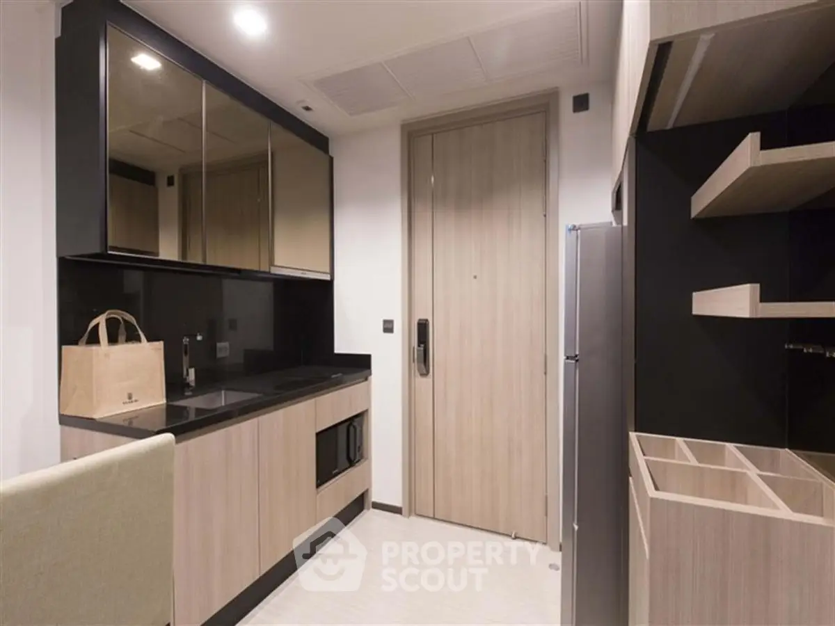 Modern kitchen with sleek cabinets and built-in appliances in a compact layout.