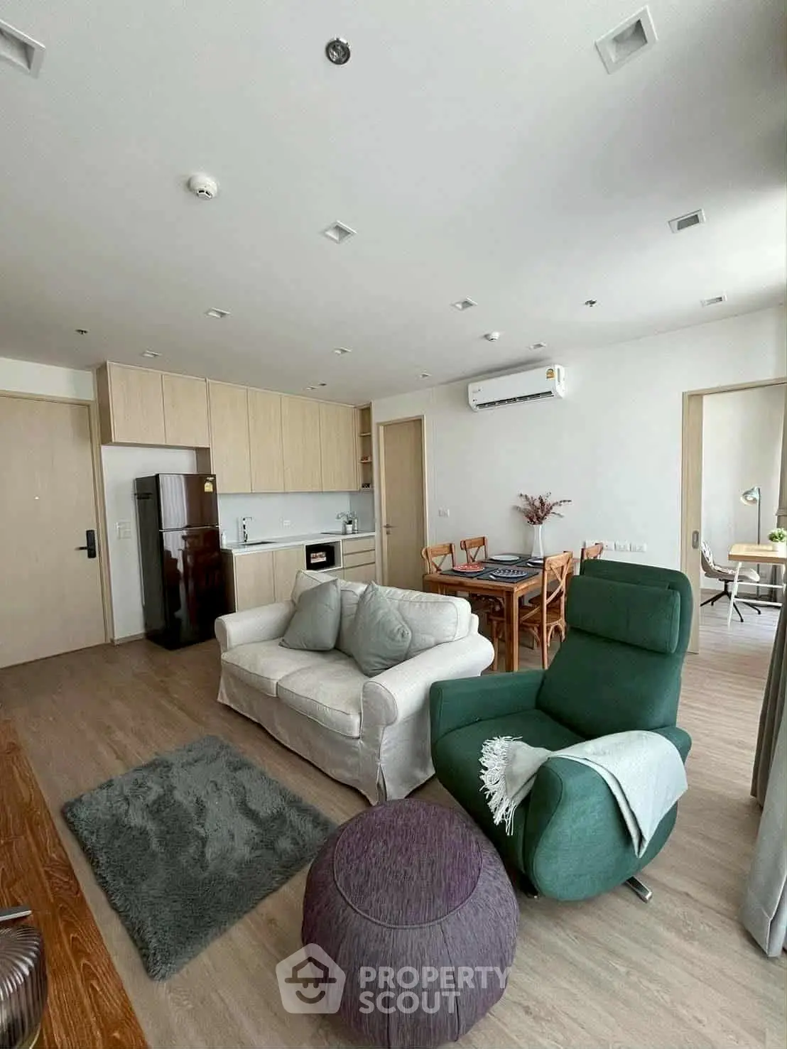 Modern living room with cozy seating and open kitchen layout in stylish apartment.