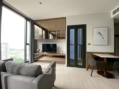 Modern living room with large windows and stylish decor in a high-rise apartment.