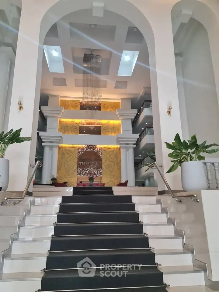 Luxurious hotel lobby with grand staircase and elegant decor
