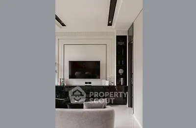 Modern living room with sleek black entertainment unit and wall-mounted TV.