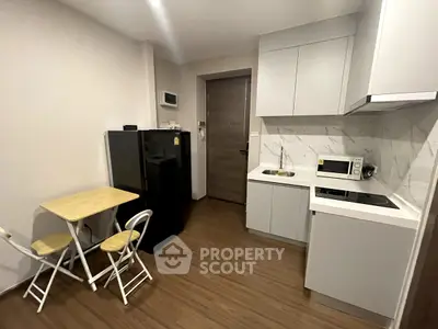 Modern compact kitchen with sleek appliances and cozy dining area