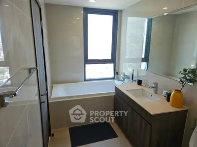 Modern bathroom with large window and sleek fixtures in a contemporary apartment.