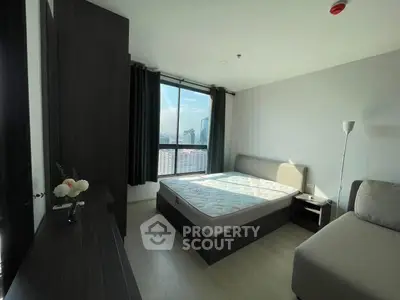 Modern bedroom with city view, featuring a comfortable bed and stylish decor.