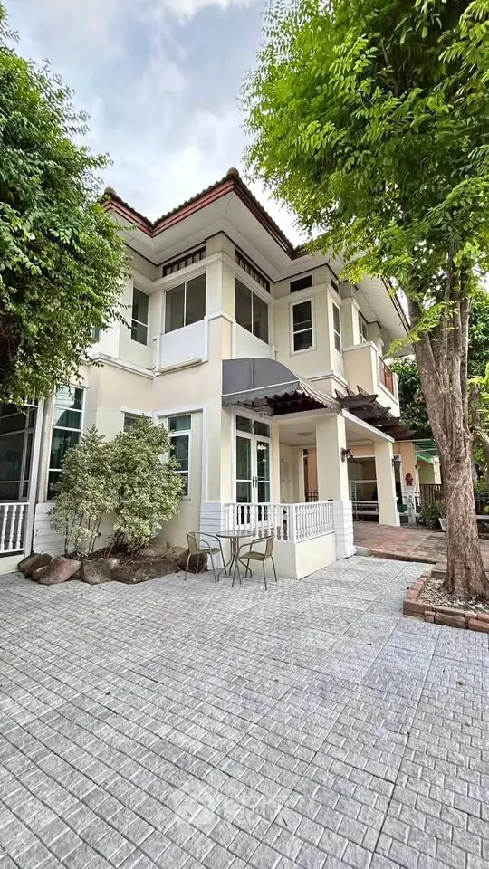 Charming two-story house with lush greenery and spacious patio