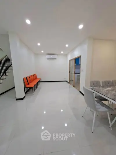 Spacious modern living room with sleek tile flooring and stylish dining area.