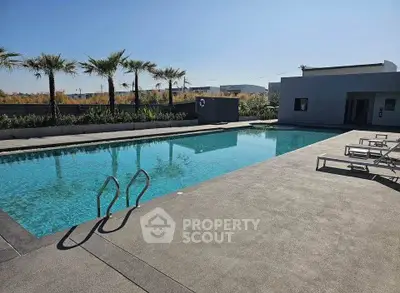 Luxurious outdoor pool area with palm trees and modern design, perfect for relaxation and leisure.