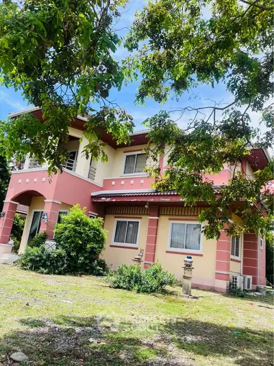 Charming two-story house with lush garden and vibrant exterior colors, perfect for family living.