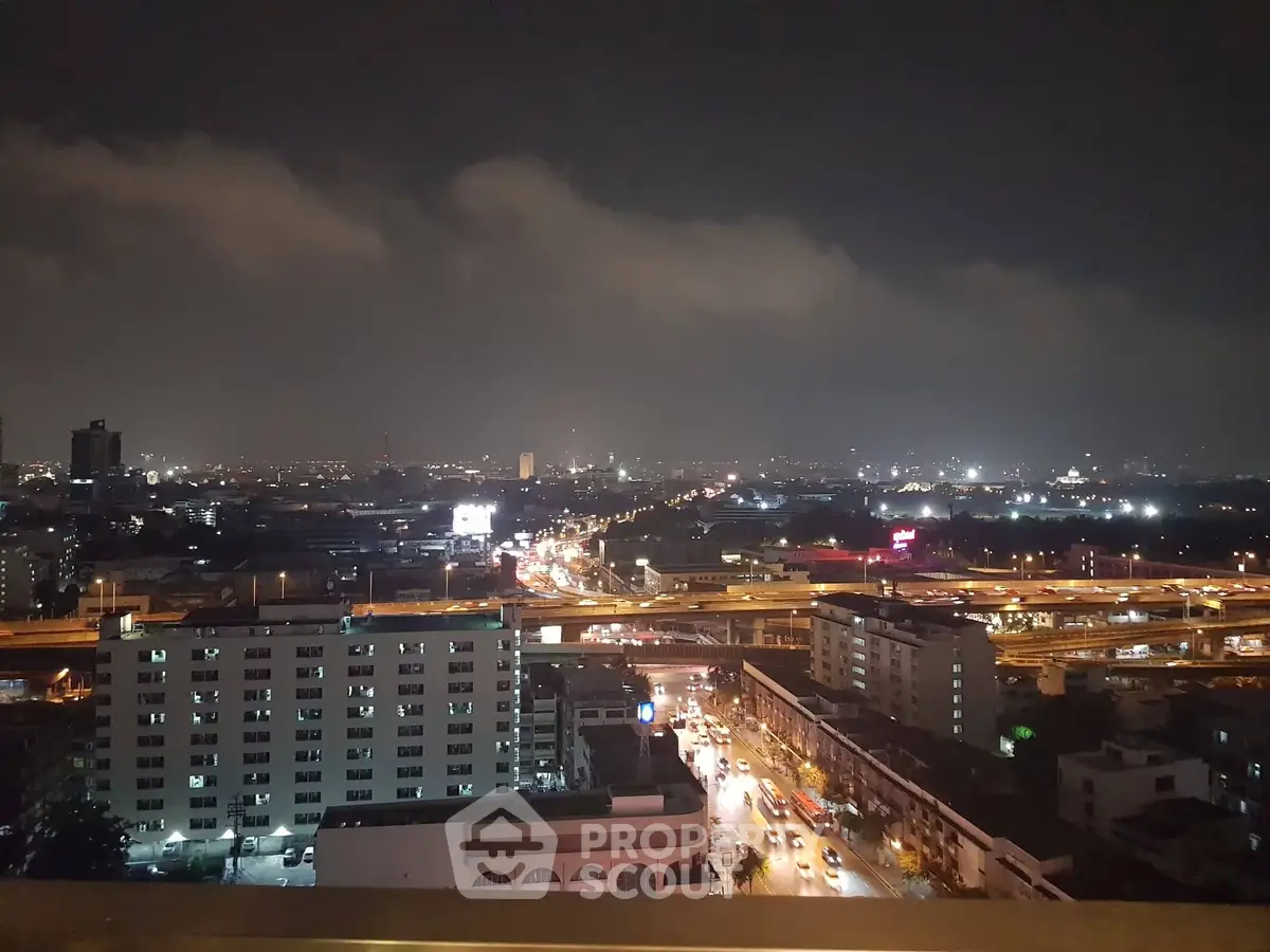 Stunning cityscape view from high-rise building at night, showcasing vibrant urban lights and skyline.