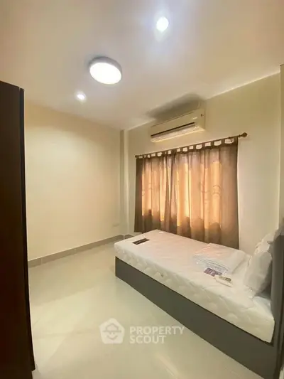 Cozy bedroom with single bed and air conditioning, perfect for a comfortable living experience.