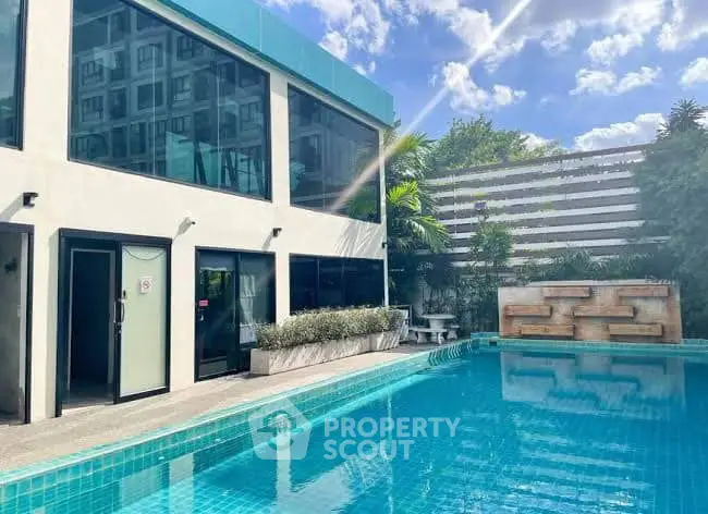 Luxurious modern building with a stunning outdoor pool and lush greenery, perfect for relaxation.