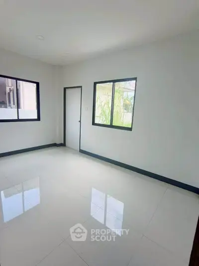 Spacious empty room with large windows and glossy white tiles