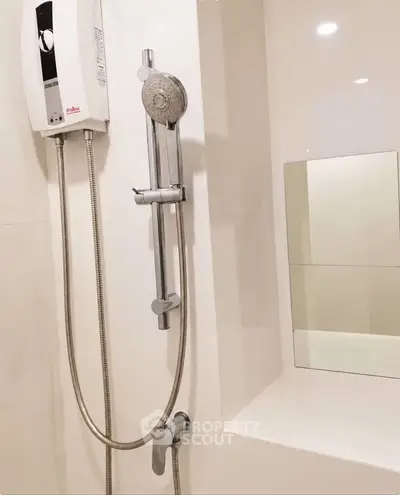 Modern bathroom with sleek showerhead and water heater, featuring a minimalist design and neutral tones.
