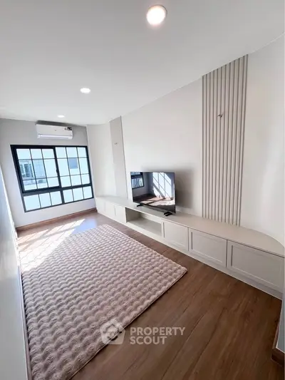 Modern living room with stylish TV unit and large window for natural light