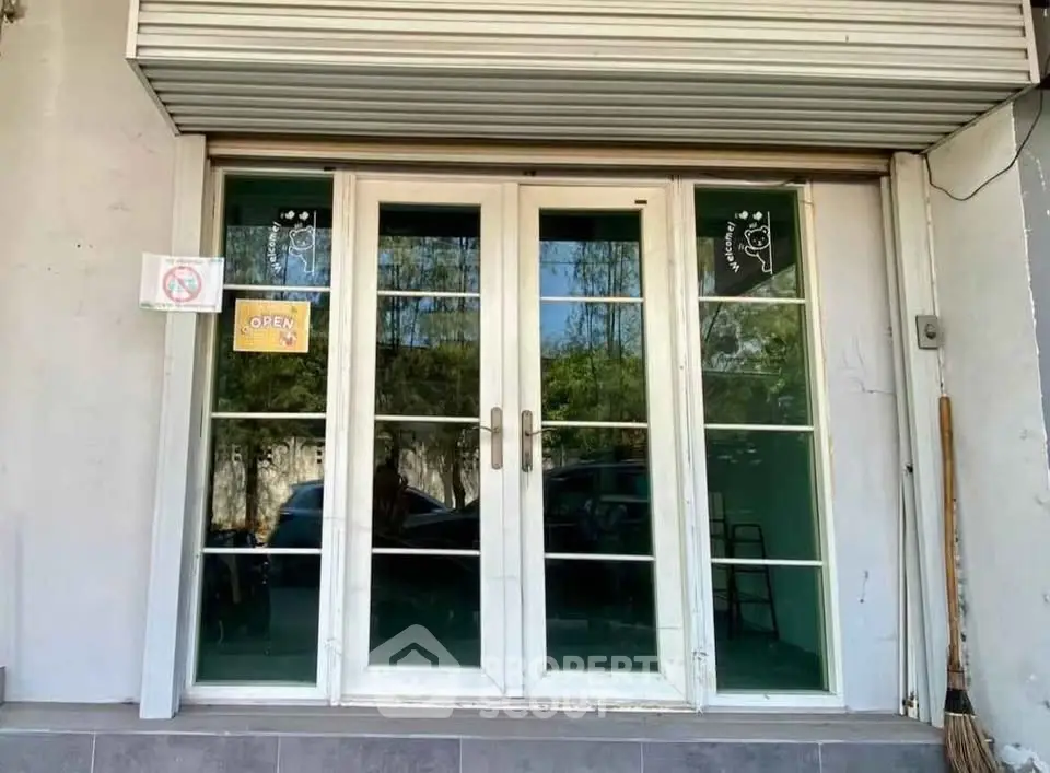 Charming storefront entrance with glass double doors and inviting open sign.