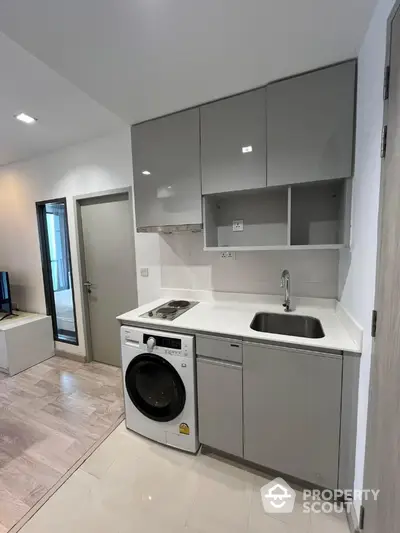 Modern compact kitchen with washing machine and sleek cabinetry