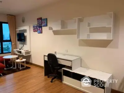 Modern study area with desk, chair, and wall shelves in cozy apartment.