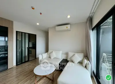 Modern living room with sleek design and natural light, featuring a cozy white sofa and stylish coffee table.