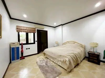 Spacious bedroom with elegant decor and natural light, featuring a cozy bed and modern furnishings.