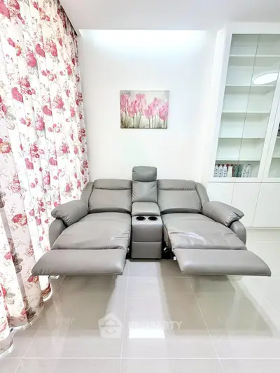 Modern living room with stylish recliner sofa and floral curtains, perfect for relaxation and comfort.