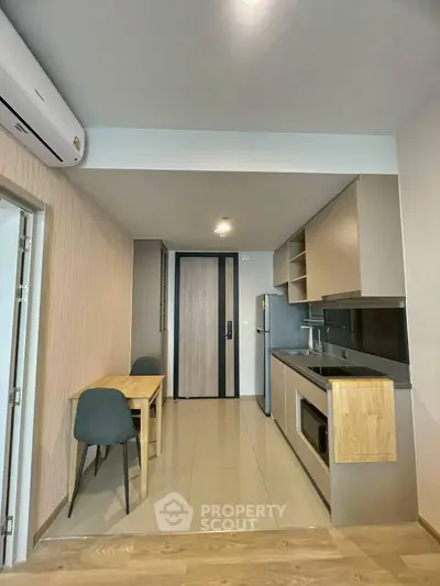 Modern kitchen with sleek cabinetry and dining area in a stylish apartment