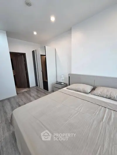 Modern bedroom with sleek design and ample natural light, featuring a comfortable bed and stylish wardrobe.