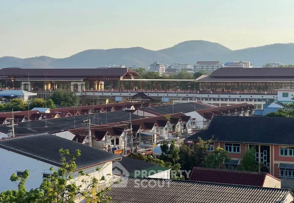 Scenic view of residential area with mountain backdrop, showcasing traditional architecture and serene surroundings.